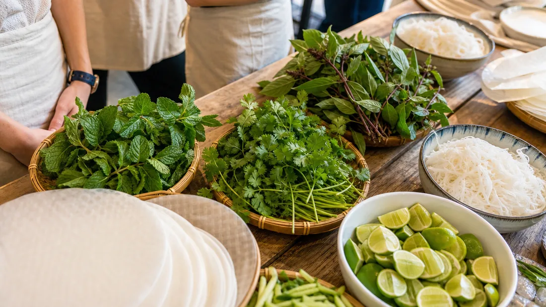 Fresh mint, coriander, rice noodles, and rice paper laid out for a Vietnamese cooking class in a Singapore studio